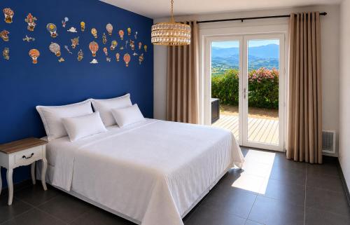 a bedroom with a white bed and a blue wall at Villa Muvra in Ajaccio