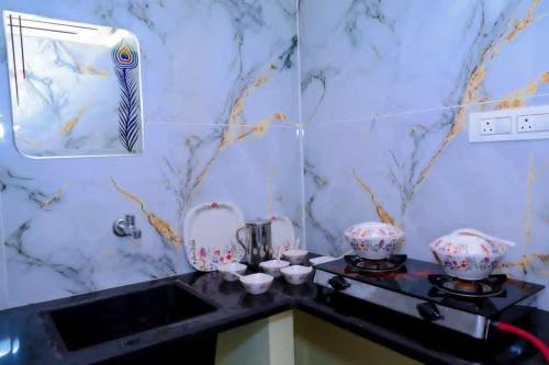 a bathroom with a counter with a sink and a mirror at Loki guest House in Chikmagalūr
