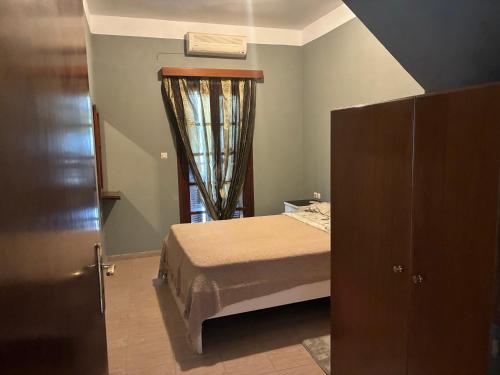 a small bedroom with a bed and a window at Vila Theodora in Myrties