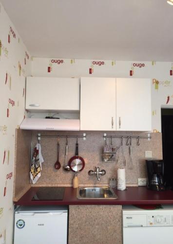 a kitchen with white cabinets and a sink at Airport Apartment in Sofia