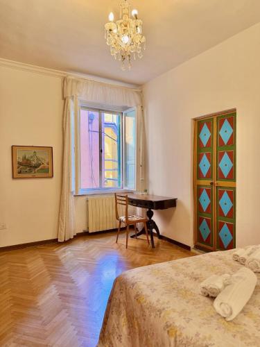a bedroom with two beds and a table and a window at La Dolce Vita in Pisa