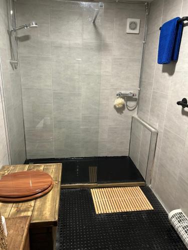 a shower with a wooden toilet in a bathroom at The Bru Bus in Maybole