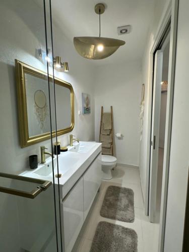 a white bathroom with a sink and a toilet at Ar Doce in Portel
