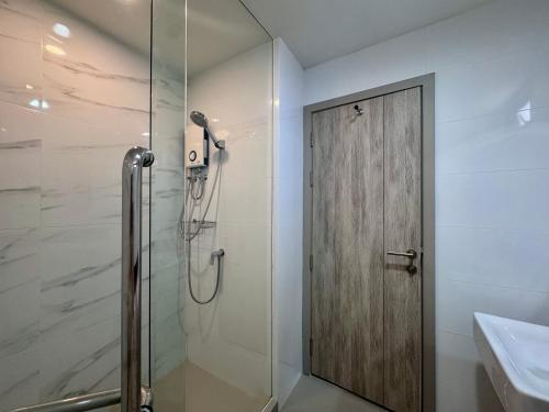 a shower with a wooden door in a bathroom at 101 Residence in Amphoe Phra Khanong