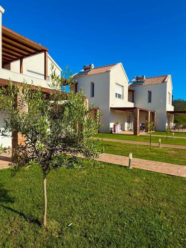 a house with a tree in the middle of a yard at Dimis Luxury Suites in Paralia Sikias