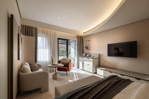 a hotel room with a bed and a living room at Monte Mulini Adults Exclusive Hotel by Maistra Collection in Rovinj