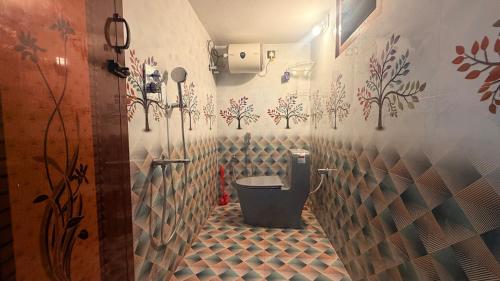 a bathroom with a toilet with flowers on the wall at Sky Haven Resort - Private Pool Villa near ECR in Kottaikadu