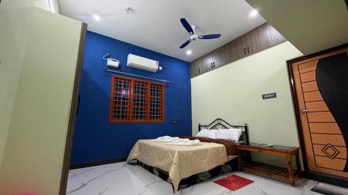 a bedroom with a blue wall with a bed in it at Sky Haven Resort - Private Pool Villa near ECR in Kottaikadu