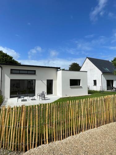 a white house with a fence in front of it at Le Cottage Bigouden in Combrit