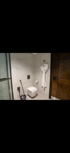 ein Badezimmer mit Toilette und einer Schaufensterpuppe an der Wand in der Unterkunft ريف دنن in Al-'Ula