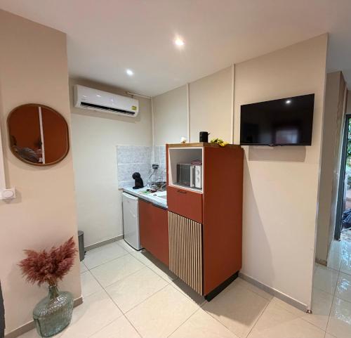 a small kitchen with a microwave and a counter at Résidence les maquis in Koungou