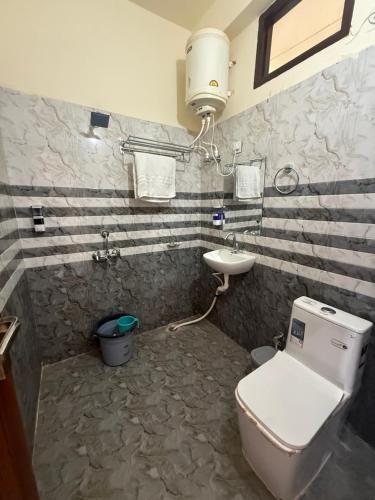 a bathroom with a toilet and a sink at Corn Village Retreat in Mussoorie