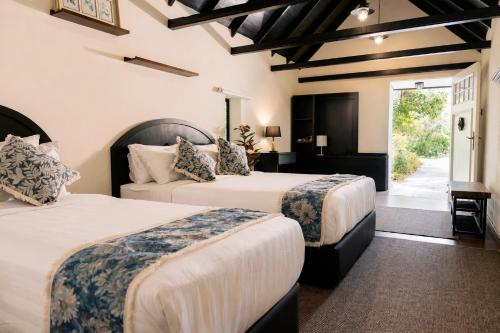 a hotel room with two beds and a doorway at Rasah Golfers Cottage in Tanah Rata
