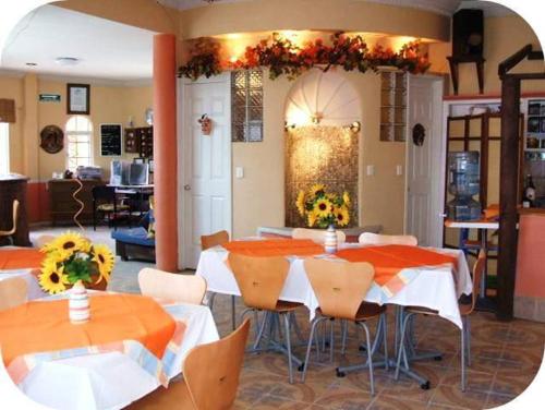 un comedor con mesas y sillas con flores. en Hotel El Refugio, en Tlaxcala de Xicohténcatl