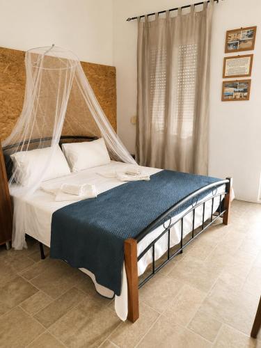 a bedroom with a bed with a mosquito net at Aloni Studio in Azoyirás