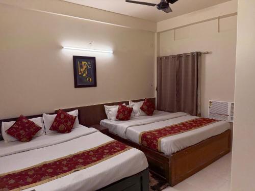 a bedroom with two beds with red pillows at HOTEL BREEZE NEW JALPAIGURI in Siliguri