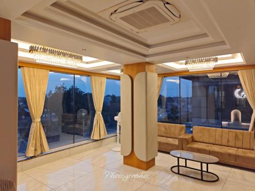a living room with a couch and a large window at Hotel Apex in Pilol