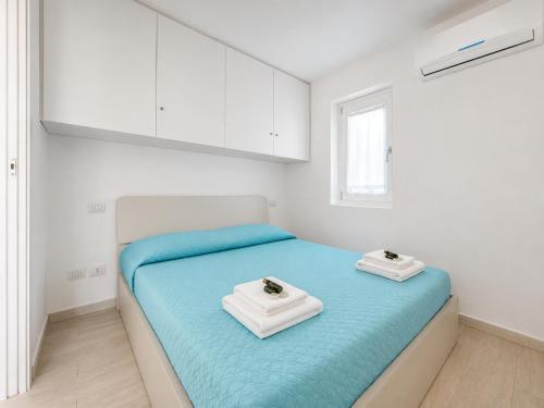 a bedroom with a blue bed with white cabinets at Renew Terrace F with Swimming Pool 70m from the Beach in Baja Sardinia