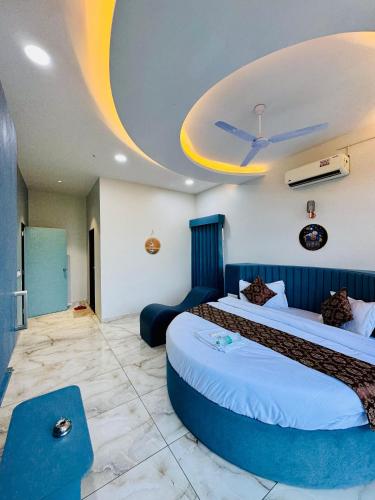 a hotel room with two beds and a ceiling at Hotel JD Fortune in Anand