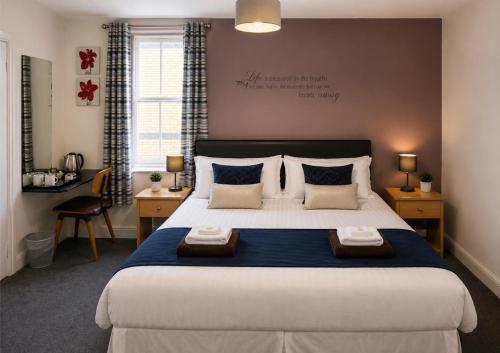 a bedroom with a large bed with two pillows at Hampton Hotel in Llandrindod Wells
