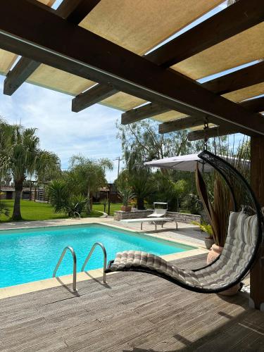 a hammock next to a swimming pool at The Bamboo villa in Casale la Cogna