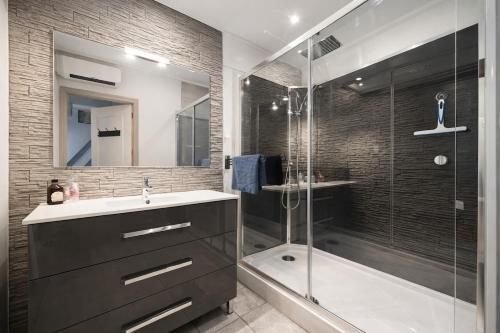 a bathroom with a shower and a sink and a tub at Chez Louis - Central Triplex in Rethel