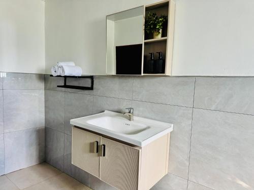 a bathroom with a sink and a mirror at Revo Apartments in Lusaka