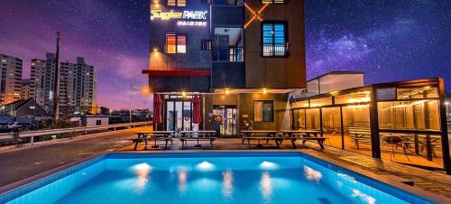 a swimming pool in front of a building at night at Boryoung Eagle Spark Pension in Boryeong