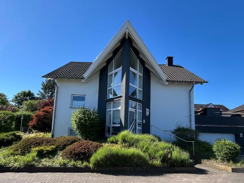 a house with a black and white at Apartment Akazie in Weinsheim