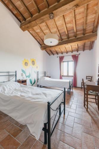 a bedroom with four beds and a wooden ceiling at Agriturismo Melariano in Castelnuovo Berardenga