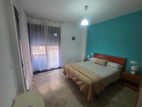 a bedroom with a bed and a blue wall at APARTAMENTO CONSTITUCIÓN in Benicarló