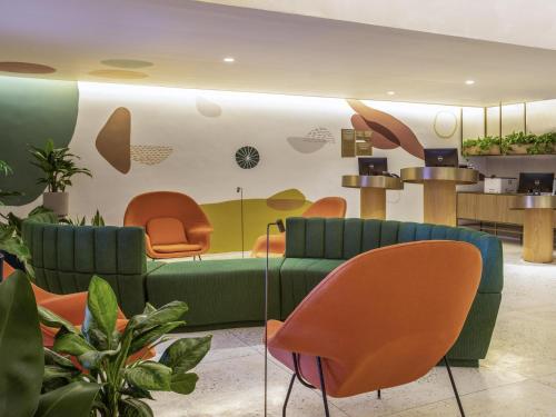 a waiting room with green furniture and orange chairs at Mercure Rio Boutique Hotel Copacabana in Rio de Janeiro