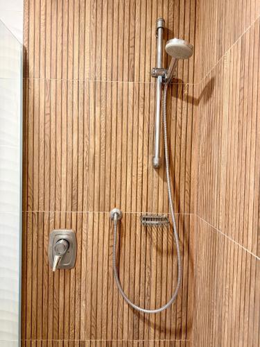 a shower with a hose on a wooden wall at Gasthof Fersterer in Lamprechtshausen