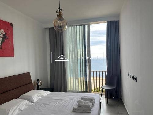 a bedroom with a bed and a view of the ocean at Green Coast 244d - by Ale Investa in Palasë
