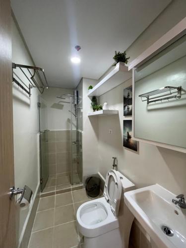 a bathroom with a toilet and a shower and a sink at Jade Mantle Sanctuary in Manila