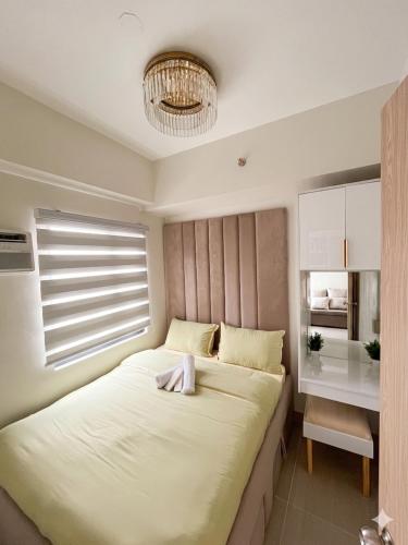 a bedroom with a large bed and a chandelier at Jade Mantle Sanctuary in Manila