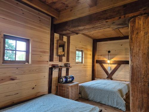 a bedroom with two beds in a log cabin at WIATRAK in Brenno