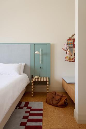 a bedroom with a white bed and a table at Owston Hotel in Fremantle