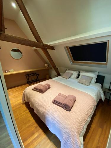 a bedroom with a large bed with two towels on it at Maison l'amitié in Ellezelles