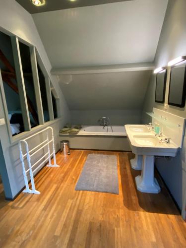 a bathroom with a sink and a bath tub at Maison l'amitié in Ellezelles