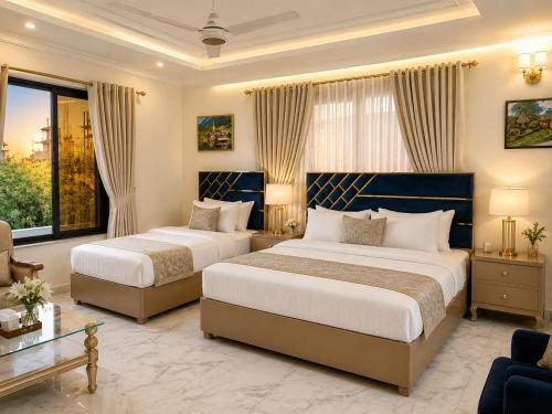 a hotel room with two beds and a window at Grand Residency Guest House in Islamabad