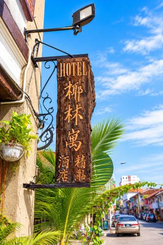 a hotel sign hanging on the side of a building at Palm Mansion Boutique Suites in George Town