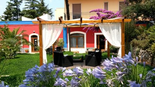 a garden with a pergola and purple flowers at Ape Rossa in Castellana Grotte