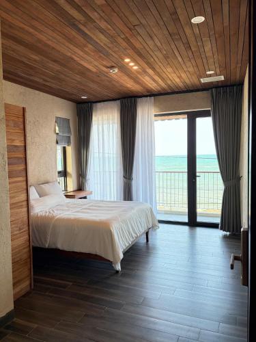 a bedroom with a bed and a large window at Phuongvilla Đông Hải in Thôn Ðông Giang