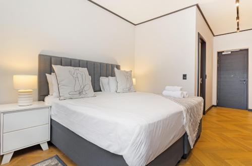 a bedroom with a large bed with white sheets at Nine Palms Studio Retreat Century City in Cape Town