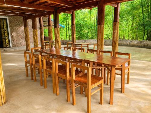 a group of wooden tables and chairs in a pavilion at Mai Chau Ecohouse in Mai Châu