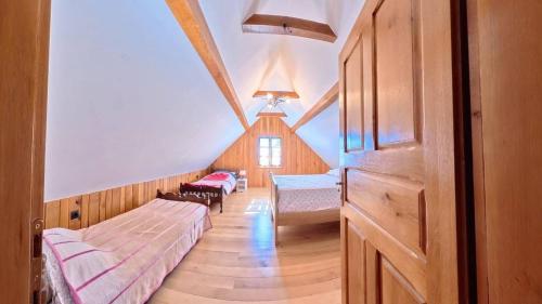 a room with a bed and a table in a attic at Sekin Vinograd in Voloder