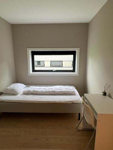 a bedroom with a bed in front of a window at Oppheimhamna 10c in Bø