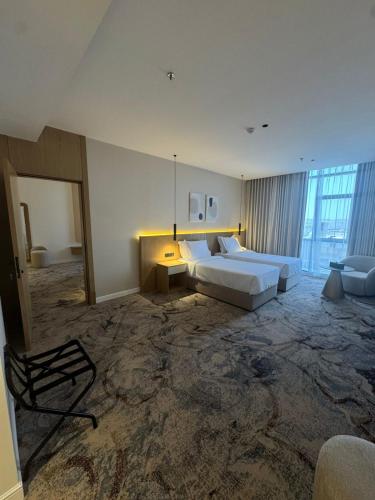 a large room with two beds and a chair in it at فندق بيات سيتي in Taif