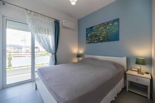 a bedroom with a bed and a large window at Antonis Studio in Archangelos